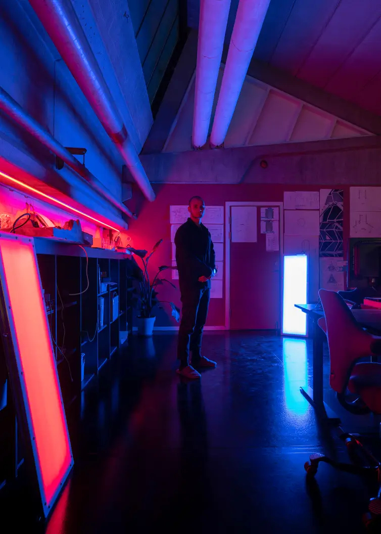 Sebastian standing in our office at night with red and blue light from some prototype LED panels